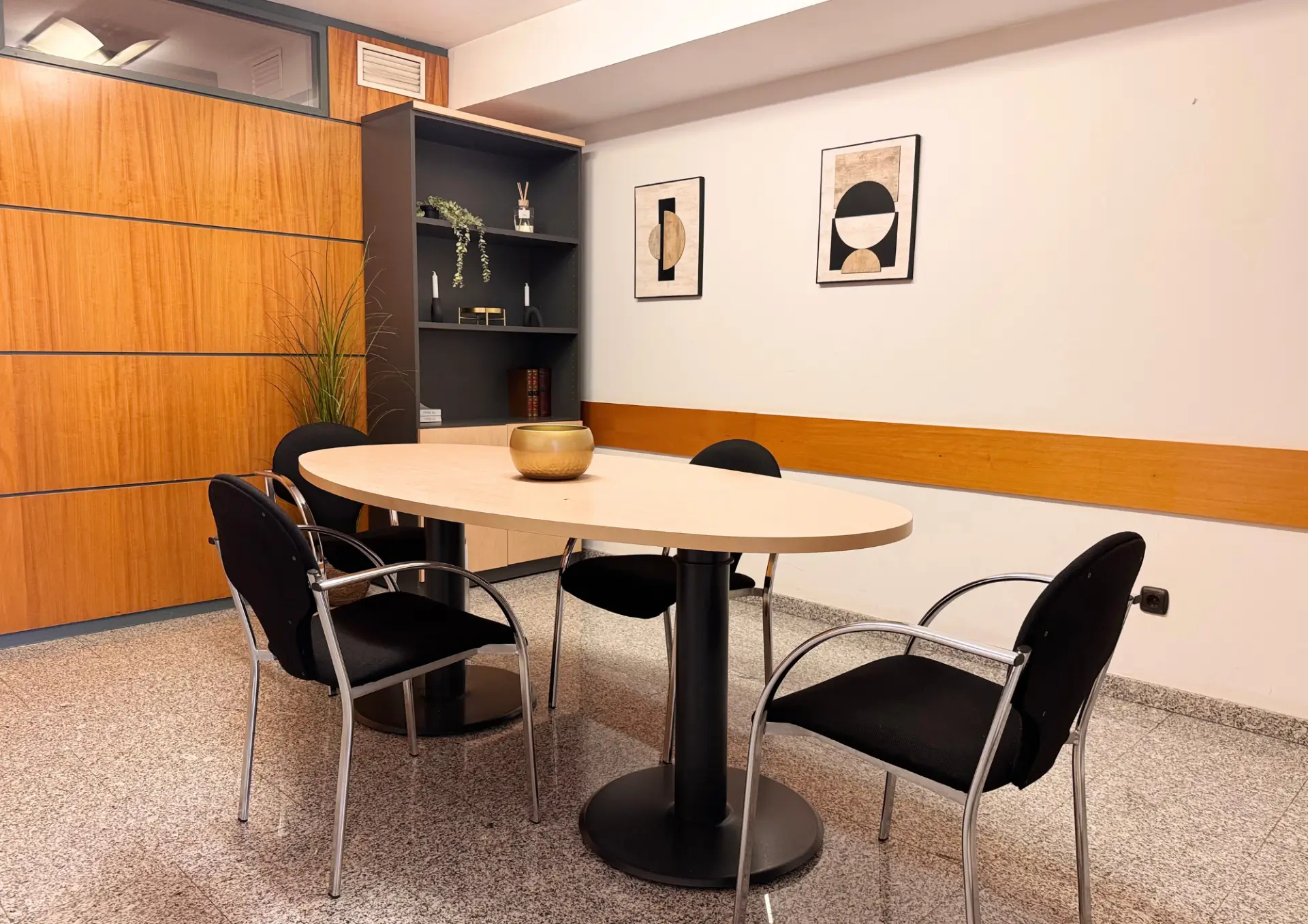 Sala de reuniones con mesa de madera y sillas negras